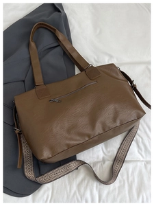 Detail of brown PU tote bag with litchi texture and patterned detachable shoulder strap