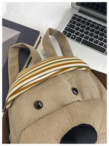 Detail of khaki corduroy puppy backpack with striped handle and 3D cute features