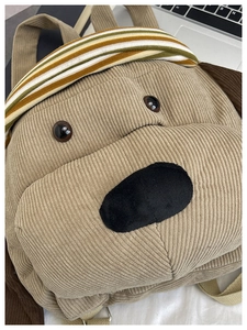 Macro shot of khaki corduroy puppy backpack texture with colorful striped headband detail
