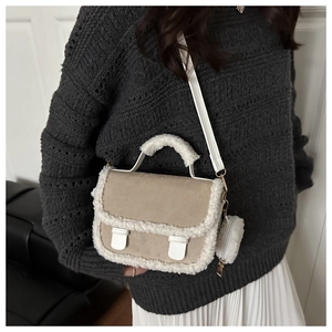 Detail of suede saddle bag featuring faux fur trim and matching round coin purse accessory