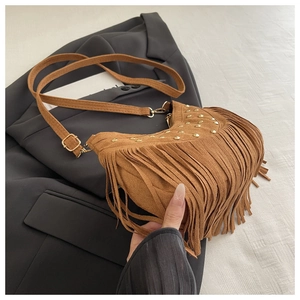 Detail of brown suede crescent bag featuring vintage gold rivets and long fringe tassels
