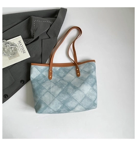 Top view of a canvas tote bag with blue diamond pattern and brown leather straps