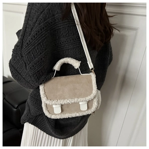 Dettaglio borsa a tracolla in pelle scamosciata beige con bordi in lana di agnello bianca