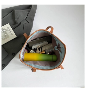 Spacious interior of blue denim tote bag with leather trim holding tablet and daily items
