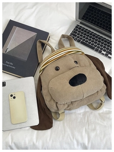 Detailed corduroy dog backpack shown with laptop and books in a campus lifestyle setting