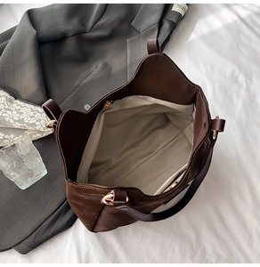 Detailed top view of large brown tote bag interior with herringbone lining and magnetic clasp