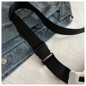 Detail of black nylon strap with adjustable plastic buckle on a crossbody chest bag