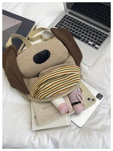 Detail of cute puppy corduroy backpack with colorful striped pocket on white fabric