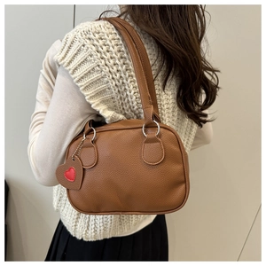 Sac bowling en cuir marron grainé avec anneaux argentés et breloque en forme de cœur