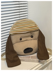 Detailed close-up of brown corduroy backpack featuring a 3D cartoon puppy design with hat
