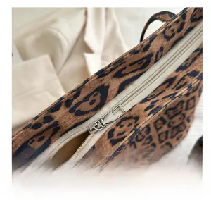 Close-up of smooth silver zipper and soft leopard print texture on a tote bag