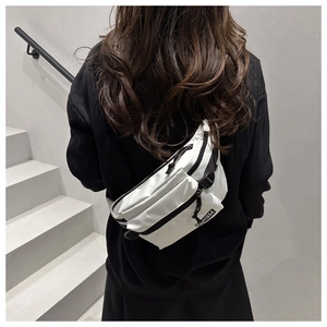Close-up of a white minimalist sports chest bag with a black zipper and adjustable strap