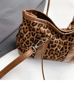 Detail of leopard print bucket bag with brown leather trim and silver metal hook buckle
