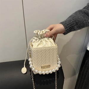 Chic woven pearl bucket bag in creamy white with gold chain and drawstring closure