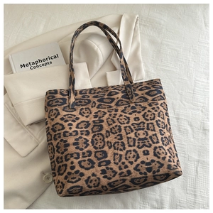 Detailed view of leopard print tote bag placed with a blazer for a chic commuter look