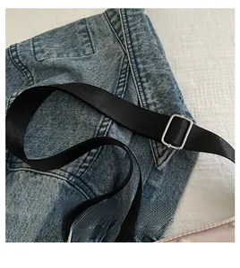 Detail of adjustable black nylon shoulder strap with silver metal buckle on handbag