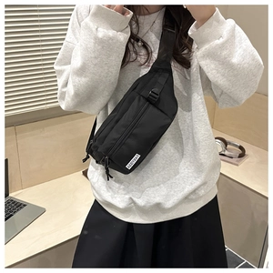 Close-up of black waterproof nylon chest bag with adjustable strap and brand label detail
