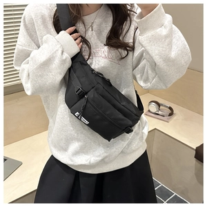 Detail of adjustable strap and plastic buckle on black multifunctional crossbody bag