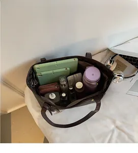 Macro view of monogram tote bag interior showing large capacity for laptop and cosmetics