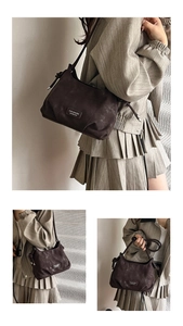 Detail of dark brown faux suede crossbody bag featuring side knot design and metal logo