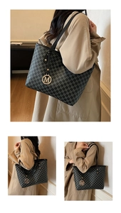 Detail of black tote bag featuring M-letter print and golden metallic logo pendant