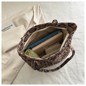 Interior detail of large leopard print tote bag showing storage capacity for books and umbrella