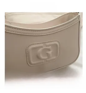 Detailed macro of ivory leather crossbody bag featuring an embossed G-letter logo design