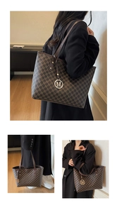 Detail of a brown tote bag featuring all-over monogram pattern and metal M charm