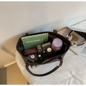 Top view of spacious brown tote bag interior filled with daily essentials and tablet