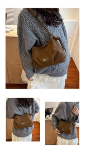 Close-up of retro brown faux leather shoulder bag with white contrast stitching details