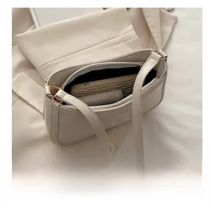Internal capacity of beige underarm bag showing space for phone and cosmetics