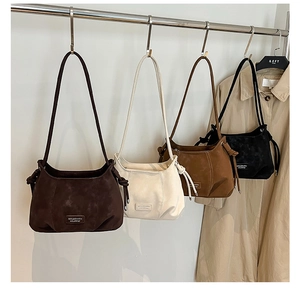 Detail of four fashionable suede dumpling bags showing soft texture and side knot accents