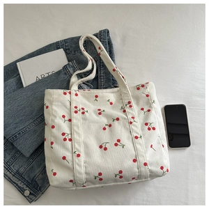 Détail d'un sac cabas en velours côtelé blanc avec imprimés cerises et grande capacité