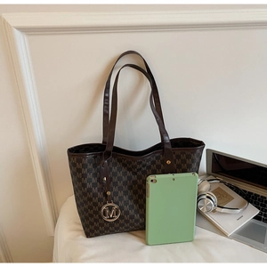 Detailed view of monogram tote bag showing large capacity with tablet and accessories