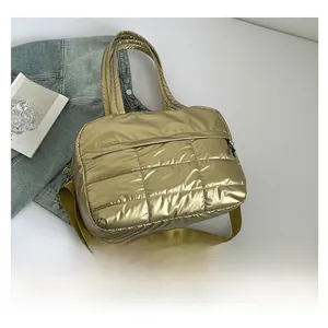 Detailed shot of champagne gold quilted tote bag with smooth texture and adjustable strap
