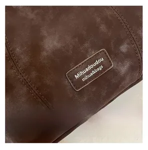 Detailed macro view of dark brown faux suede material and stitched leather brand logo