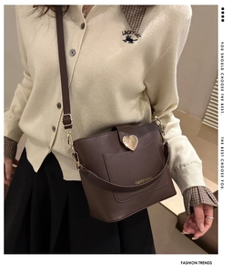 Détail du sac seau marron avec fermoir coeur doré et longue bandoulière