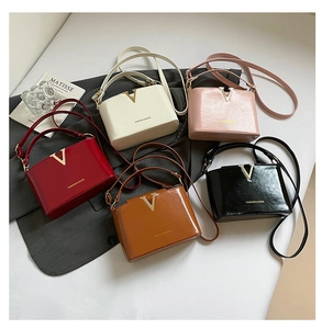 Flat lay view of five colorful bucket bags with V-shaped buckles and adjustable straps