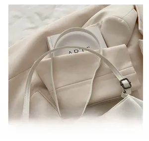 Close-up of adjustable cream leather strap with dark grey metal buckle and fine stitching