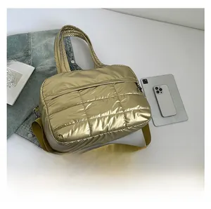 Detail of golden quilted tote bag with double handles and adjustable nylon shoulder strap