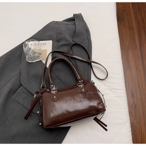 Dettaglio della borsa Boston in pelle testa di moro con borchie argentate e nappine
