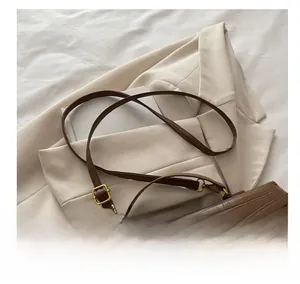 Detail of dark brown crocodile texture leather bag with vintage golden metal buckle