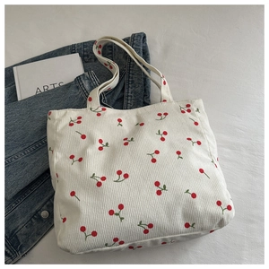 Détail du sac cabas en velours côtelé blanc cassé avec imprimé cerise sur denim