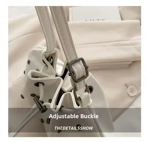 Detail of adjustable metal buckle and drawstring closure with studs on white leather bag
