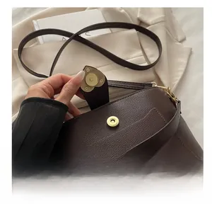 Detail of vintage gold heart-shaped magnetic clasp on dark brown lychee leather bag