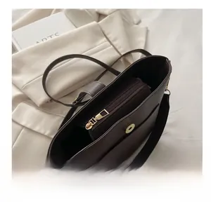Close-up of dark brown lychee pattern leather bag interior with smooth golden zipper
