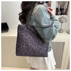 Large leopard print tote bag in dark purple and black shown on shoulder with denim jacket