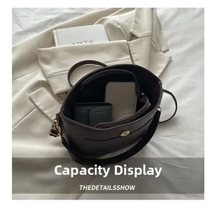 Deep brown leather bucket bag showing interior zipper pocket and spacious main compartment