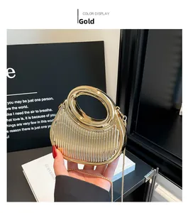 Macro shot of gold half-moon bag with vertical striped embossing and metal chain