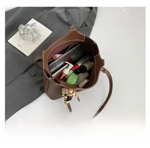 Interior storage view of brown leather tote bag with silk scarf showing daily items